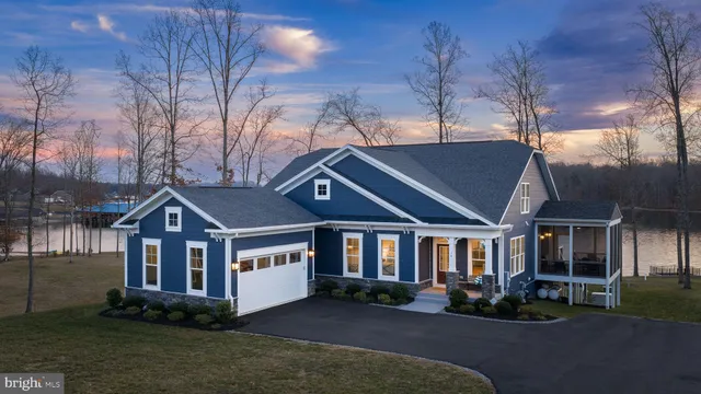 a front view of a house with a garden and trees