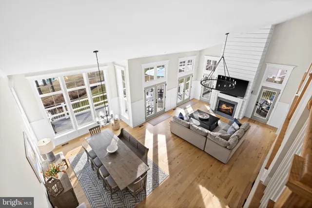 a view of a balcony with wooden chairs and floor to ceiling window