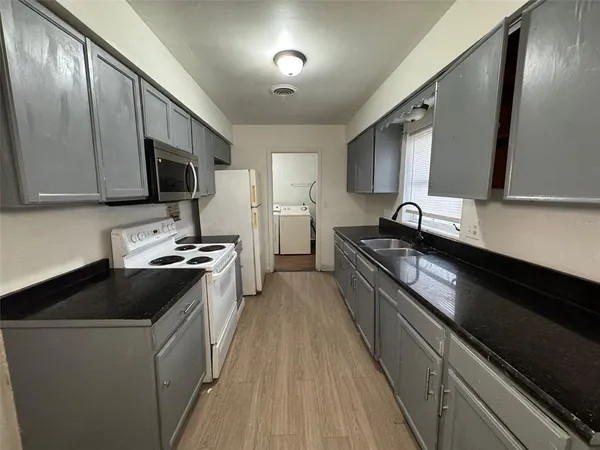a sink with white cabinets