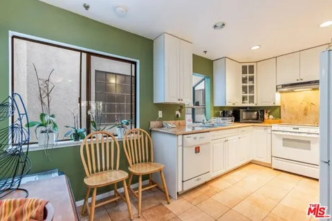 a kitchen with a chair and white appliances