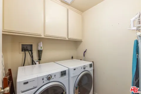 a view of washer and dryer with kitchen in the background