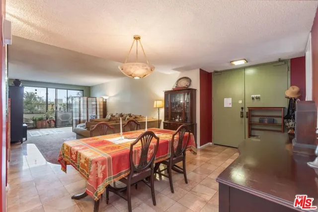 a living room with furniture a chandelier and a dining table