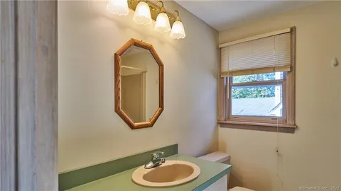 a bathroom with a toilet a sink and a mirror