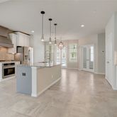 a large kitchen with stainless steel appliances kitchen island granite countertop a stove a sink a refrigerator and a granite counter tops