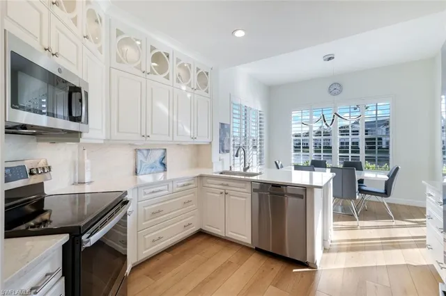 a kitchen with stainless steel appliances granite countertop a stove a sink and a microwave