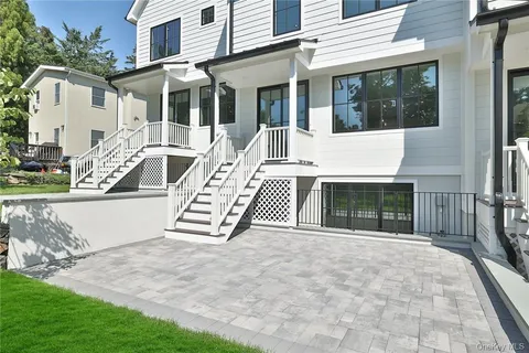 a view of a white house with many windows and yard