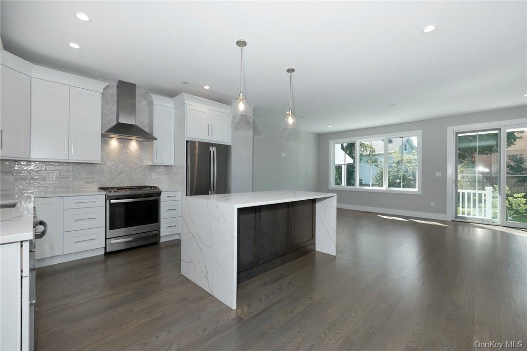 40 Devoe Street, Unit B Dobbs Ferry, NY 10522 - Photo 8 of 27 Kitchen with White Shaker Cabinetry, Stainless Steel Appliances, Tiled Backsplash, Quartz Countertops, Center Island With Double Waterfall Edge