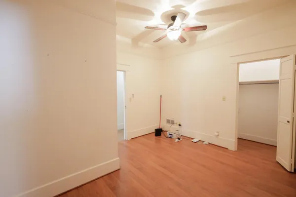 an empty room with a fan and a ceiling fan