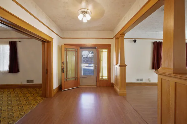 an empty room with wooden floor and windows