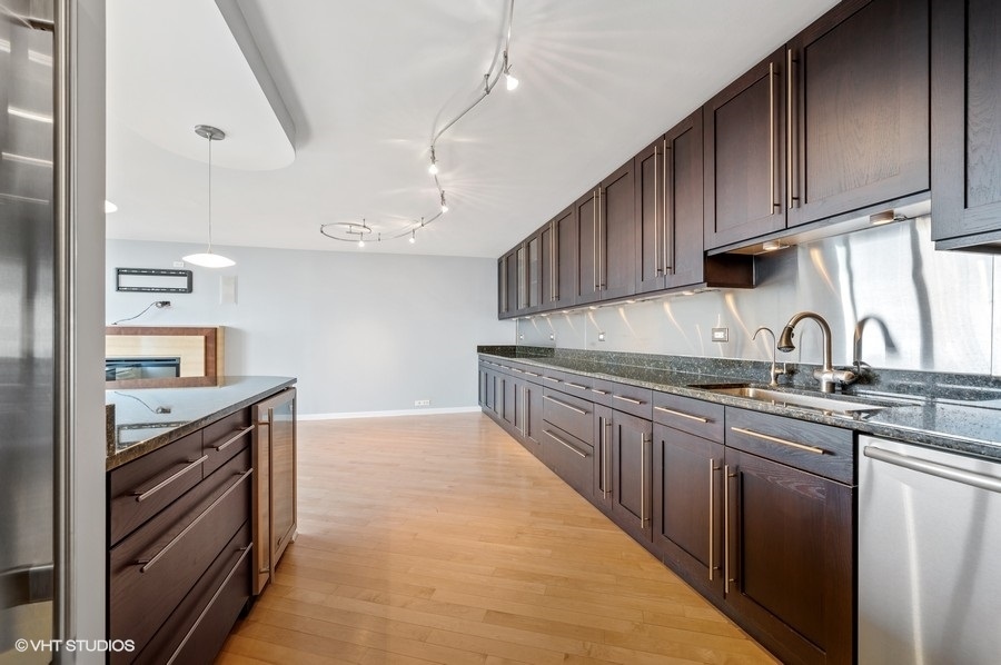 505 North Lake Shore Drive, Unit 4112 Chicago, IL 60611 - Photo 11 of 29 a kitchen with granite countertop a sink stove and cabinets