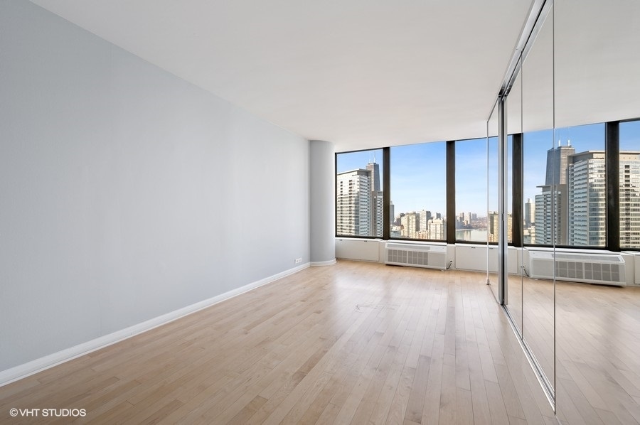 505 North Lake Shore Drive, Unit 4112 Chicago, IL 60611 - Photo 13 of 29 a view of an empty room with wooden floor and a window