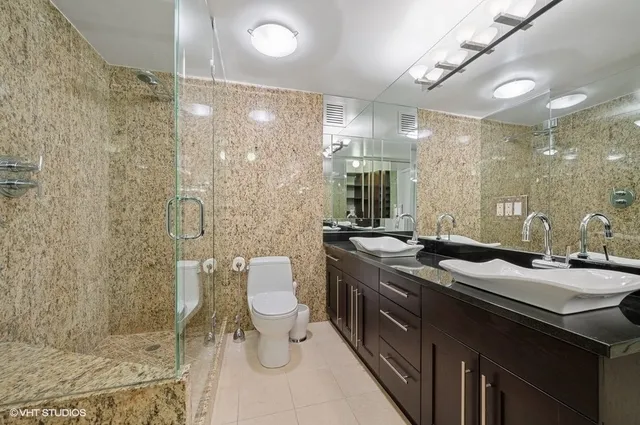 a bathroom with a double vanity sink toilet and shower