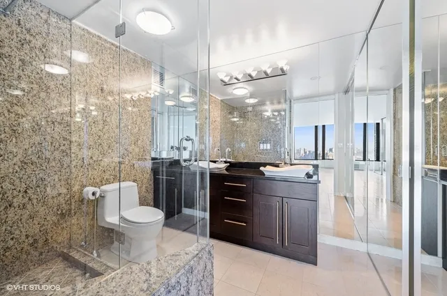 a bathroom with a granite countertop sink toilet and shower