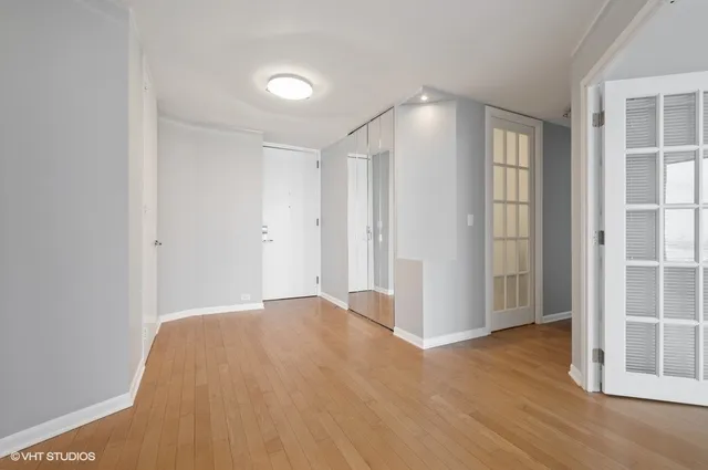 a view of empty room with wooden floor and entryway