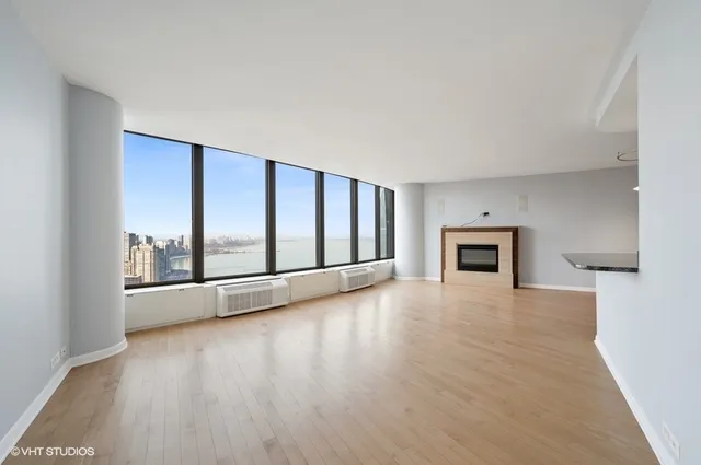 a view of empty room with wooden floor and fireplace