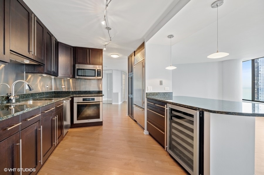 505 North Lake Shore Drive, Unit 4112 Chicago, IL 60611 - Photo 10 of 29 a large kitchen with stainless steel appliances granite countertop a stove top oven a sink and dishwasher