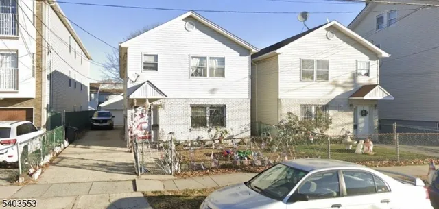 a view of a white house with large windows and a yard
