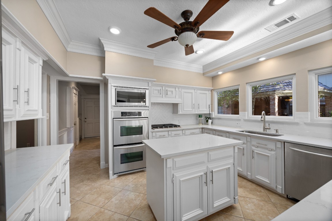 8807 Chelmsford Lane Spring, TX 77379 - Photo 18 of 50 a kitchen with a stove sink and a refrigerator