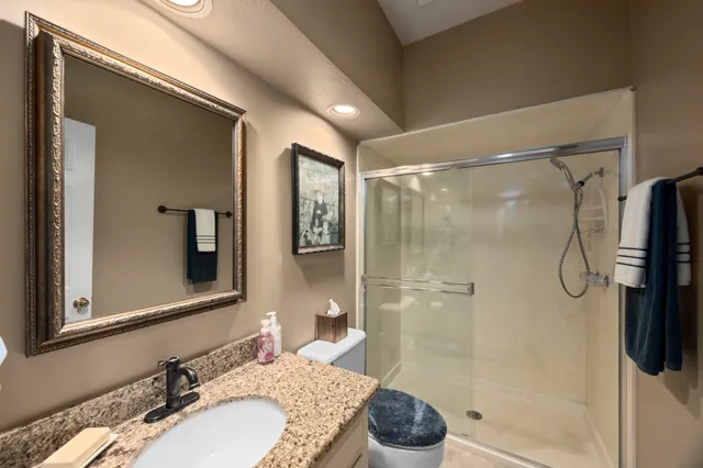 a bathroom with a granite countertop sink a shower and a mirror