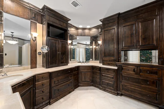 a large kitchen with stainless steel appliances wooden cabinets and a sink