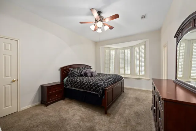 a living room with a bed furniture and a large window