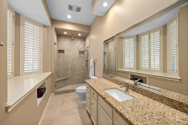 a bathroom with a granite countertop tub a sink and a large mirror