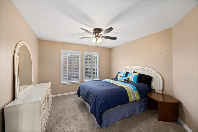 a bedroom with a bed and a ceiling fan