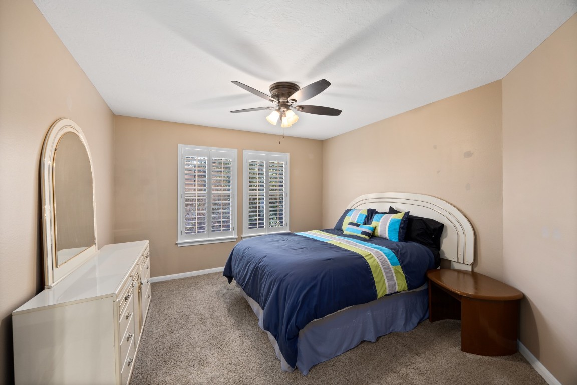 8807 Chelmsford Lane Spring, TX 77379 - Photo 36 of 50 a bedroom with a bed and a ceiling fan
