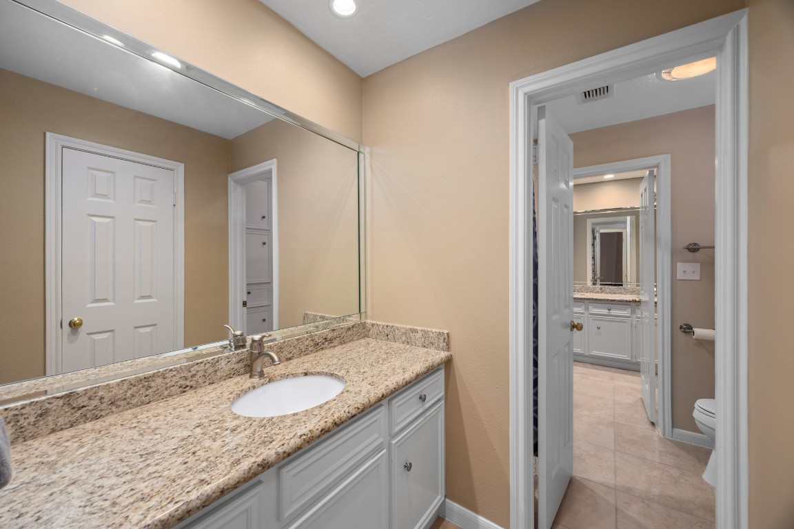 8807 Chelmsford Lane Spring, TX 77379 - Photo 37 of 50 a bathroom with a granite countertop sink and a mirror