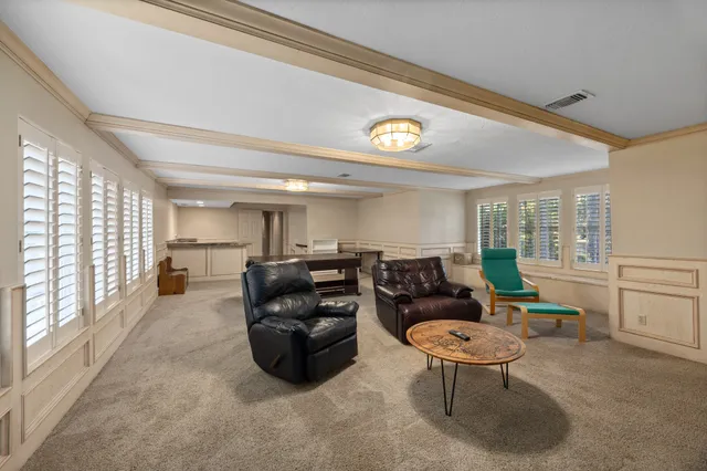 a living room with furniture a large window and chairs