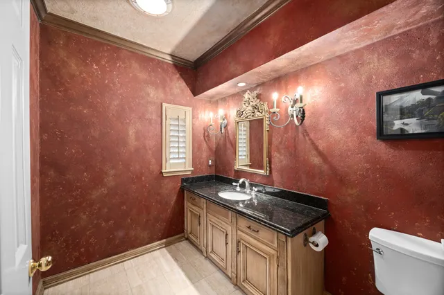 a bathroom with a granite countertop sink and a toilet