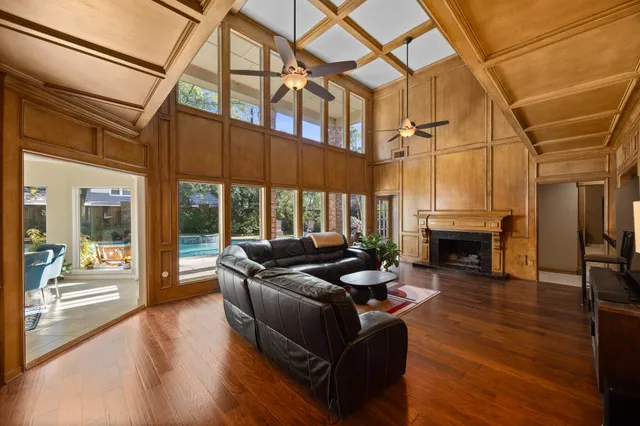 a living room with fireplace furniture and a floor to ceiling window