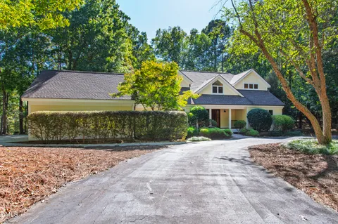 a living room with stainless steel appliances wooden floor a fireplace and a flat screen tv