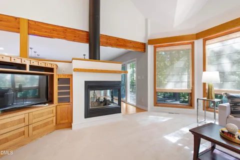 a living room with furniture a fireplace and kitchen view
