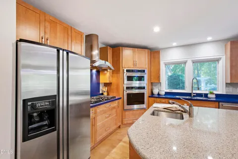 a bathroom with a sink a mirror and a potted plant
