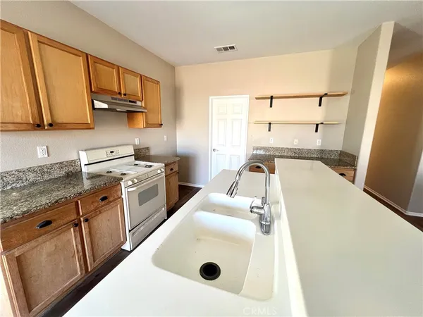 a kitchen with a sink a stove and cabinets