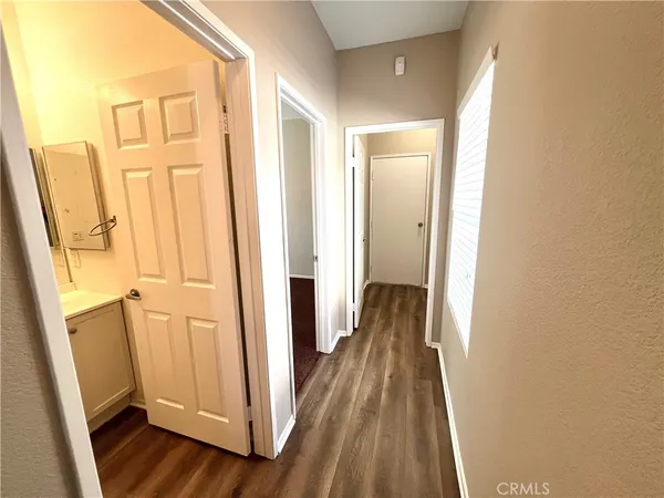 a view of a hallway with wooden floor and staircase