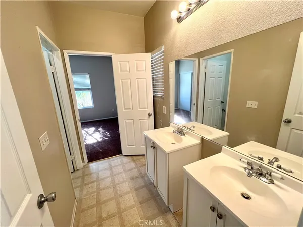 a spacious bathroom with double sink and mirror