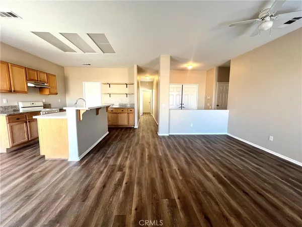 a view of a kitchen with wooden floor and stainless steel appliances