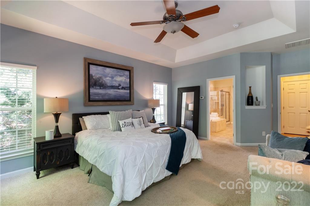 1292 Valhalla Drive Denver, NC 28037 - Photo 20 of 47 a bedroom with a bed a ceiling fan and a large mirror