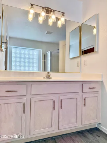 a bathroom with a sink vanity and mirror