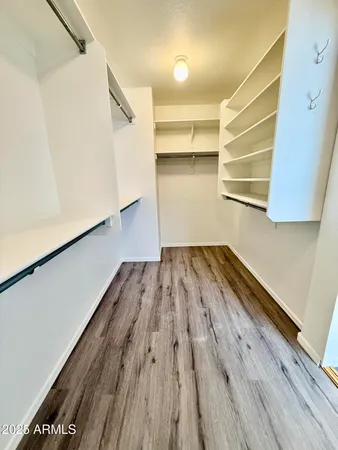 a view of a room with wooden floor and cabinets