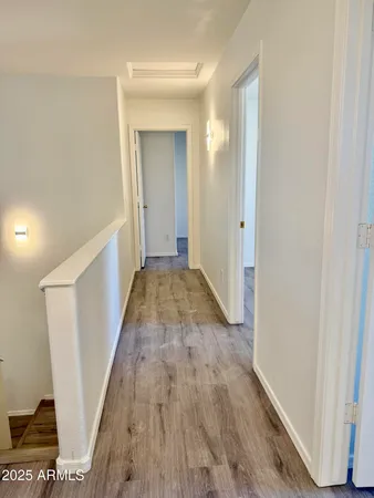 a view of a hallway with wooden floor and staircase