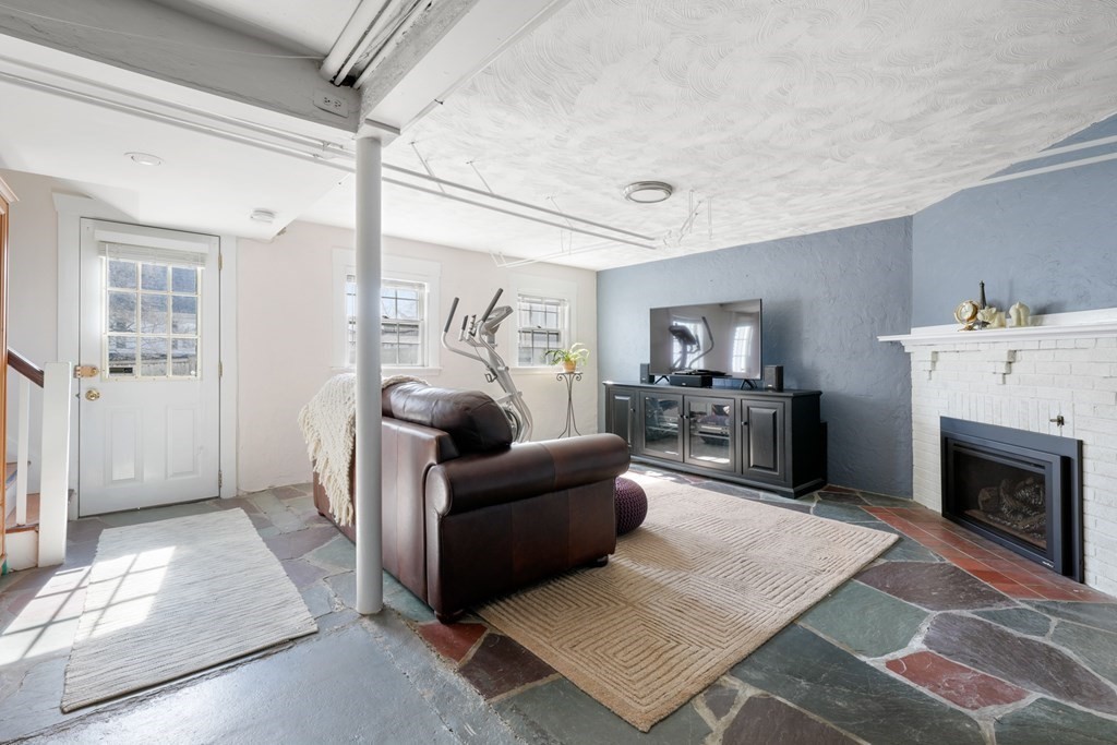 63 Standish Road Milton, MA 02186 - Photo 25 of 38 a living room with furniture a fireplace and a flat screen tv