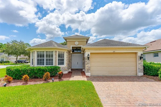 a front view of a house with a garden and plants