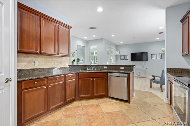 a kitchen with stainless steel appliances granite countertop wooden cabinets a sink and a stove