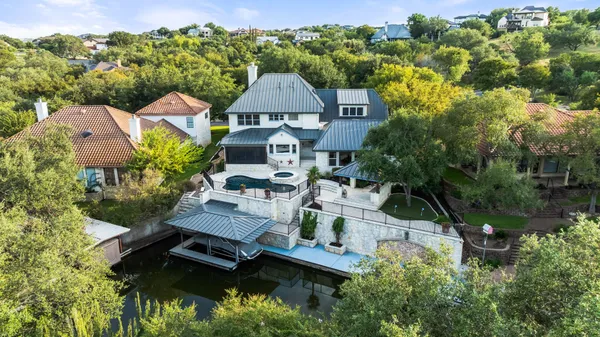 an aerial view of a house with swimming pool and outdoor seating