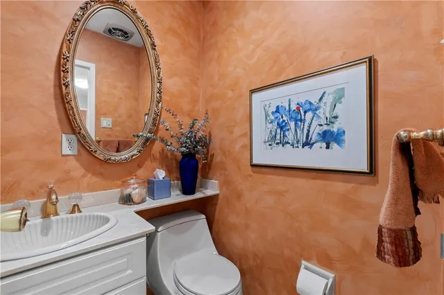 a bathroom with a toilet a sink and a mirror