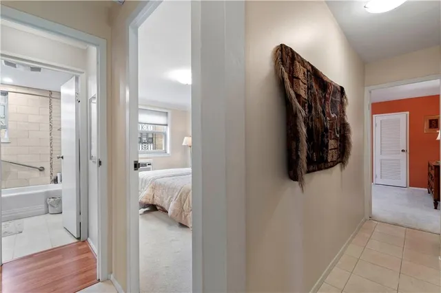 a walk in closet with wooden floor