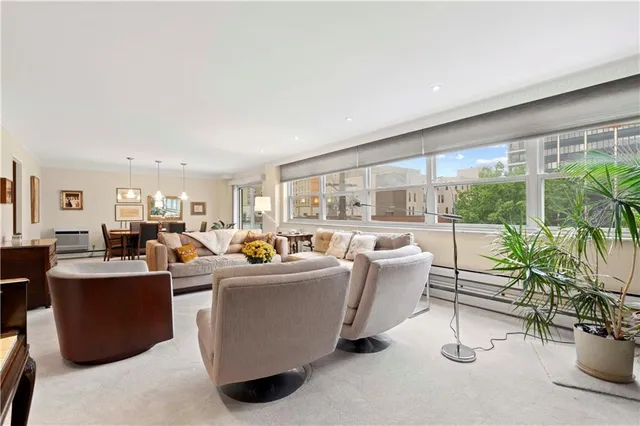 a living room with fireplace furniture and a potted plant